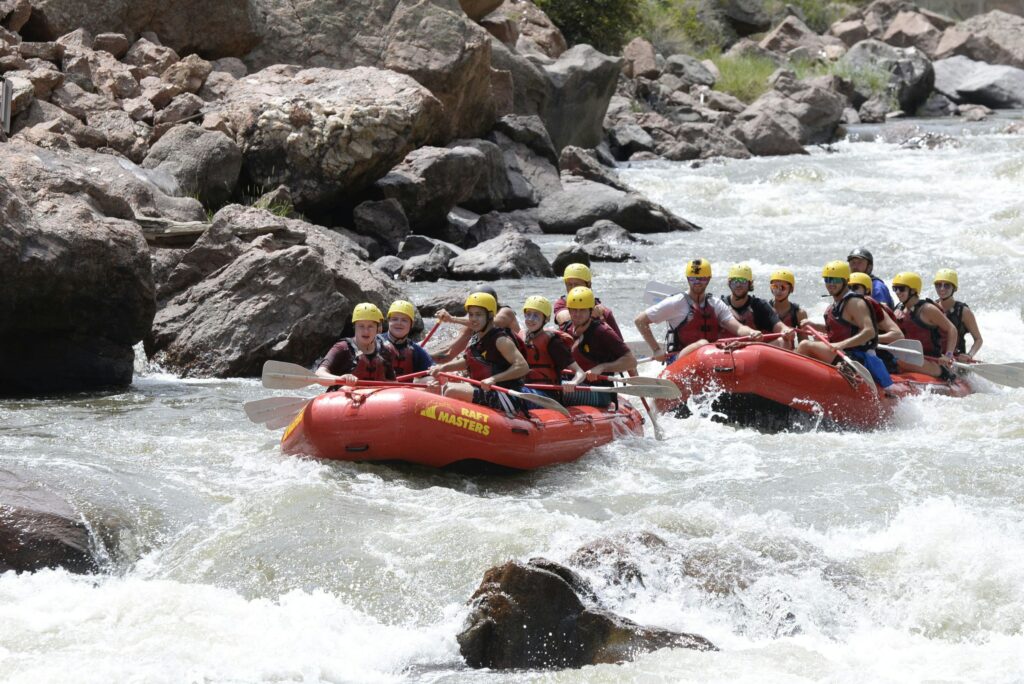 Two rafts with people on them practicing rafting at a Denver river
