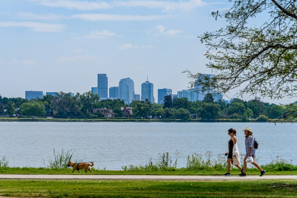 Two women walking a dog by Sloan's Lake in Denver