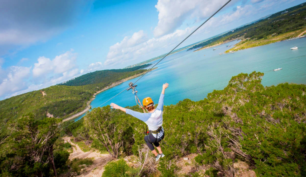 Woman ziplining with Lake Travis in the background