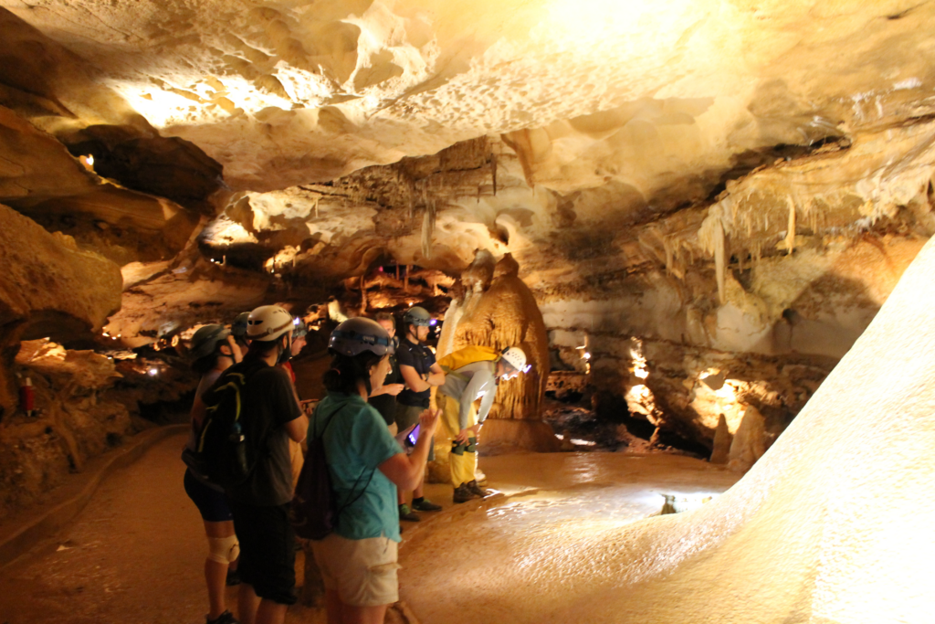 A group of students examining the "flow stone of time" at Inner Space Cavern