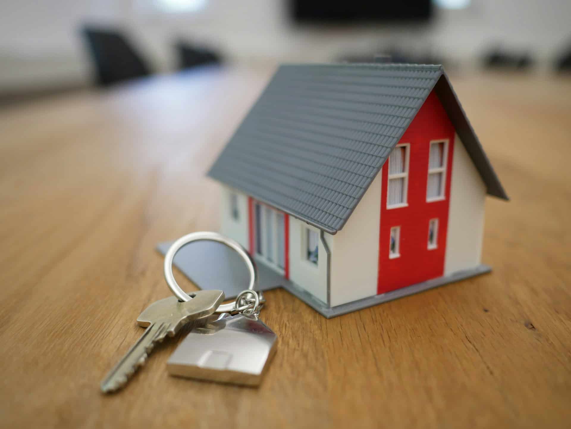 A red and white tiny house next to a set of keys