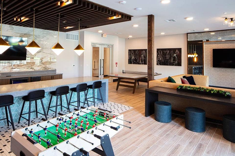 Modern game room with foosball and ping pong table in a Landing property in Dallas, TX