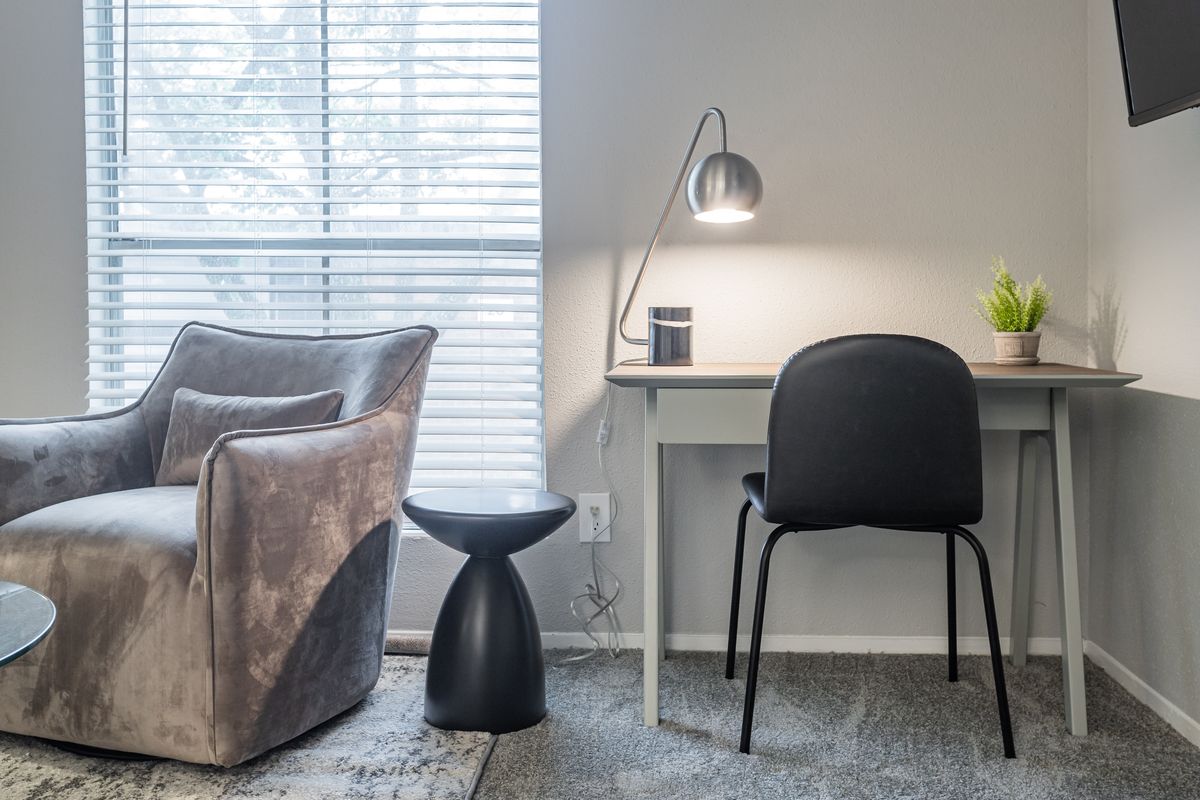 Home office corner with desk and armchair in a furnished apartment for a work assignment