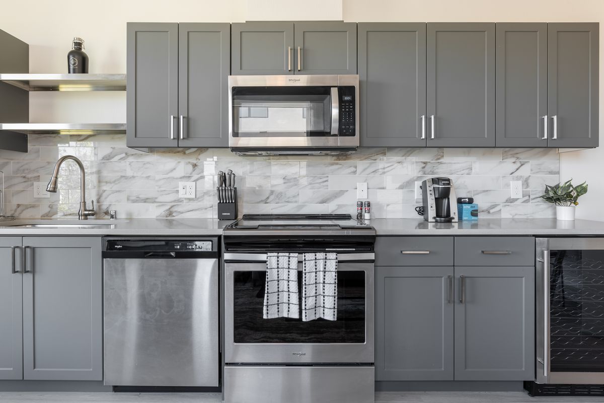 Fully equipped kitchen with stainless steel appliances in a move-in ready furnished apartment